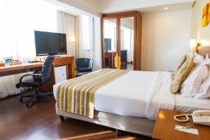 a hotel room with a bed and a desk and a computer at Quality Porto Alegre in Porto Alegre