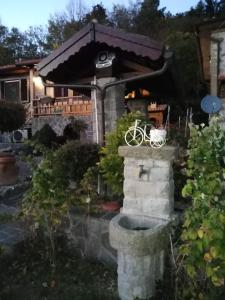 a house with a bike sitting on a stone wall at Baita La Stradella in Serravalle