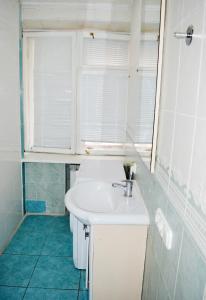 baño con lavabo blanco y ventana en Hostel Golden Gates, en Kiev