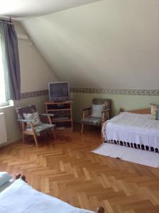 a bedroom with two beds and a television in it at Főnix Fogadó in Lenti
