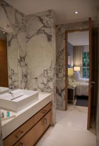 uma casa de banho com um lavatório e uma parede em mármore em Pennsylvania Suites em Cidade do México