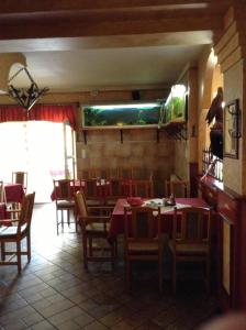 a restaurant with tables and chairs and a fishtank on the wall at Főnix Fogadó in Lenti