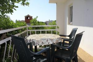 a table and chairs on the balcony of a house at Apartments Branko in Povljana