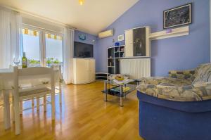 ein Wohnzimmer mit einem Sofa und einem Tisch in der Unterkunft Apartments Ljuba - nice garden in Trogir