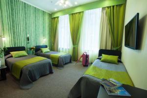 
a hotel room with two beds and two nightstands at Nevsky Contour in Saint Petersburg
