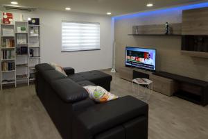 a living room with a couch and a flat screen tv at Casa Da Praia "AL" in Monte Gordo