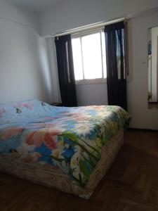 1 dormitorio con 1 cama con una manta colorida en Residencia La Perla en Mar del Plata