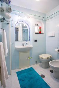 a bathroom with a sink and a toilet and a mirror at La casa del capitano in Atrani
