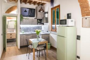 a kitchen with a table and a refrigerator at Giulia in S.Reparata in Florence