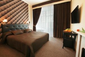 
a hotel room with a bed, chair, and nightstand at Nevsky Contour in Saint Petersburg
