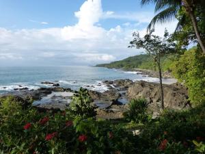 uma vista para o oceano a partir de uma praia rochosa em Luminosa Montezuma Hostel em Montezuma