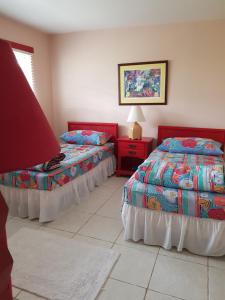 1 dormitorio con 2 camas y mesa con lámpara en Bajamar Your Second Home Guest Property, en Freeport