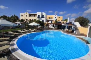 a large blue swimming pool in front of a building at Kalimera Hotel in Akrotiri