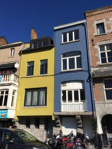 un bâtiment coloré avec des motos garées devant lui dans l'établissement Les Voisins De Mr Sax, à Dinant