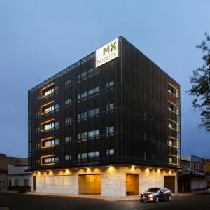 a black building with a sign on top of it at Hotel MX aeropuerto in Mexico City