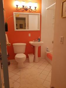 y baño con aseo, lavabo y espejo. en Bajamar Your Second Home Guest Property en Freeport