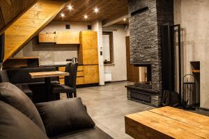 a living room with a fireplace and a table at Apartament Mountain Chalet in Szczawnica