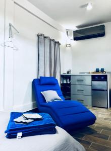 a blue chair in a room with a kitchen at Modern Suite #0 - best location in Aguadilla