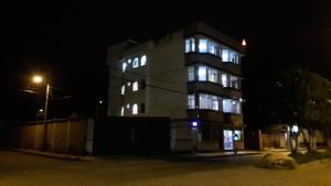 a tall building with lights on at night at HOSTAL LESLY SALOME in Tulcán