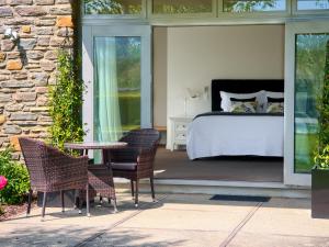 a bedroom with a bed and a table and chairs at Mt Michael Lodge in Cromwell