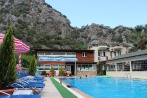 契拉勒Canada Hotel & Bungalows的一家有游泳池、椅子和山的酒店