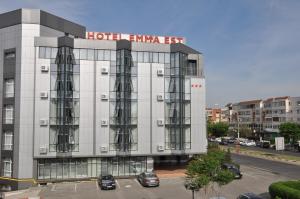 克拉约瓦Hotel Emma Est的停车场内停放车辆的酒店入口