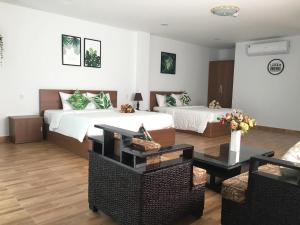 Cette chambre comprend 2 lits et une table. dans l'établissement Vic House Hotel, à Đà Nẵng