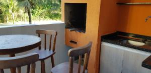 uma cozinha com uma mesa e cadeiras e um lavatório em apartamento em bertioga em Bertioga
