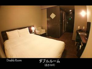a hotel room with a large white bed and a desk at Dormy Inn Premium Hakata Canal City Mae in Fukuoka