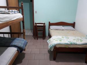 a bedroom with two bunk beds and a tiled floor at Pousada Minas Gerais in Tramandaí