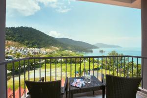 a balcony with a table and chairs and a view of the ocean at The Bayview Beach Resort in Batu Ferringhi
