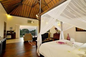 a bedroom with a bed with a white canopy at Puri Mas Boutique Resort & Spa in Senggigi