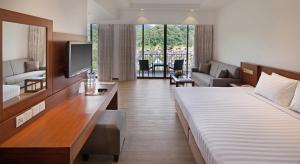 a hotel room with a bed and a living room at The Bayview Beach Resort in Batu Ferringhi