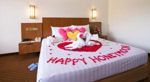 a bedroom with a bed with hearts and two swans at The Bayview Beach Resort in Batu Ferringhi