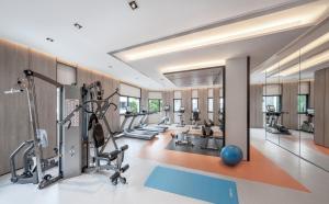 a gym with treadmills elliptical machines and a ball at Le Grove Serviced Residences in Singapore