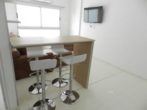 a kitchen with a bar with stools and a television at El Departamento de los Abuelos in Posadas