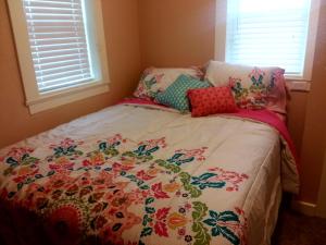 a bedroom with a bed with a floral bedspread at 1920s Rock Bungalow in Mountain Grove