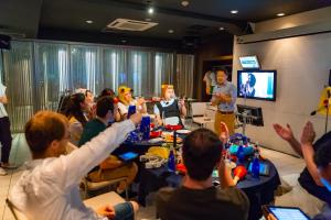 a group of people sitting around a table in a room at Sakura Hotel Jimbocho in Tokyo