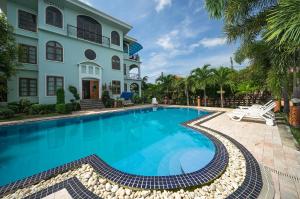 a swimming pool in front of a house at Baan Georges Hotel in Sukhothai