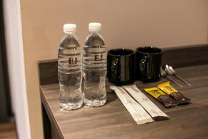 dos botellas de agua sentadas encima de un estante en Eureka Hotel Penang, en Bayan Lepas