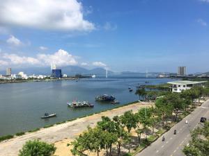 a river with boats in it with a bridge in the background at Vitalis Riverside Hotel in Danang
