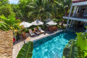 an overhead view of a swimming pool with chairs and umbrellas at The Shoreline Stay in Hoi An