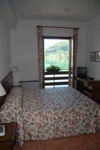 a bedroom with a bed and a large window at Hotel Acquevive in Scanno