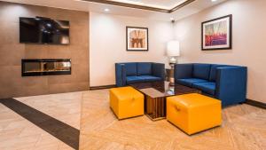 a waiting room with two blue chairs and a table and a tv at Best Western Inn at Ramsey in Ramsey