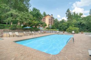 uma piscina com cadeiras e um edifício ao fundo em Gatlinburg River Inn em Gatlinburg