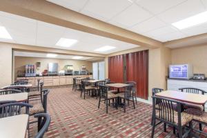 a dining room with tables and chairs and a cafeteria at Ramada Limited Cockeysville in Cockeysville