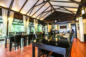 a dining room with tables and chairs and a kitchen at The Village Bunaken in Bunaken