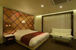 a bedroom with a bed and a couch and a table at Hotel 5stars (Adult Only) in Takamatsu