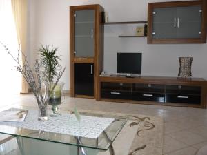 a living room with a tv and a glass table at Öreg Malom Hotel in Csepreg