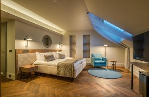 a bedroom with a bed and a blue chair at Hotel Vilnia in Vilnius